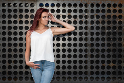 girl in front of metal wall with white shirt and blue jeans