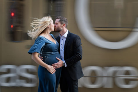denver maternity portraits of couple kissing in front of a moving train