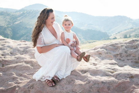 denver family portraits of mother and daughter wearing white sitting on red rocks