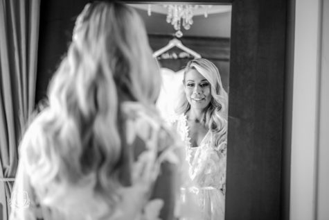 black and white image of bride looking in mirrow